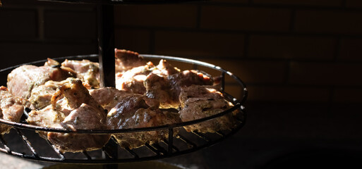 Appetizing fried meat in cast iron frying pan close-up on blurred dark background