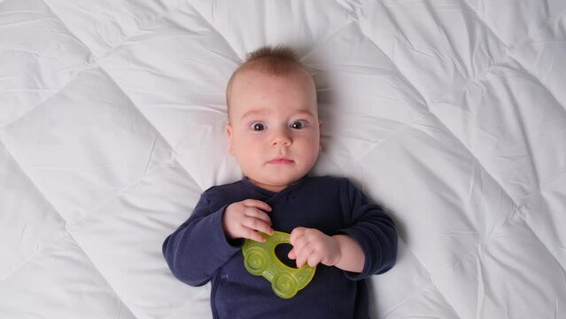 perplexed intrigued baby boy use teeth toy infant with yellow teether comfort childhood environment, rest moment