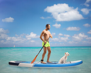 Young fit man with a puddle on a sup board with a dog