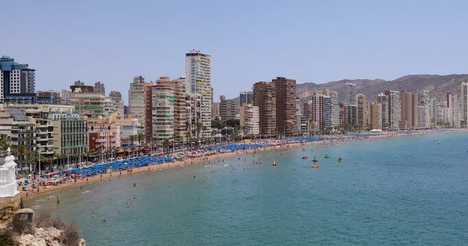 Footage of the beautiful city of Benidorm in Spain in the summer time showing high rise apartments and building along side the Levante Beach on a sunny summers day