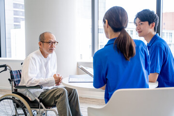 Obraz premium カウンセリングする介護スタッフとシニア男性