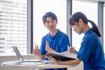 男女の介護士の打合せ