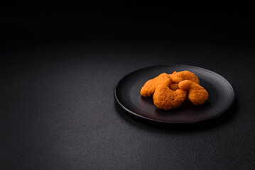 Delicious fresh crispy chicken nuggets on a dark concrete background