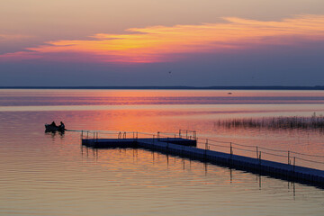 Obraz premium summer sunset on lake with boat
