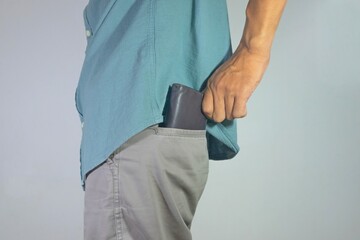 Man pull out his leather wallet from back pocket pant.