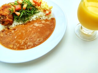 Traditional Brazilian meal named prato feito and cup of cashew juice with copy space.

