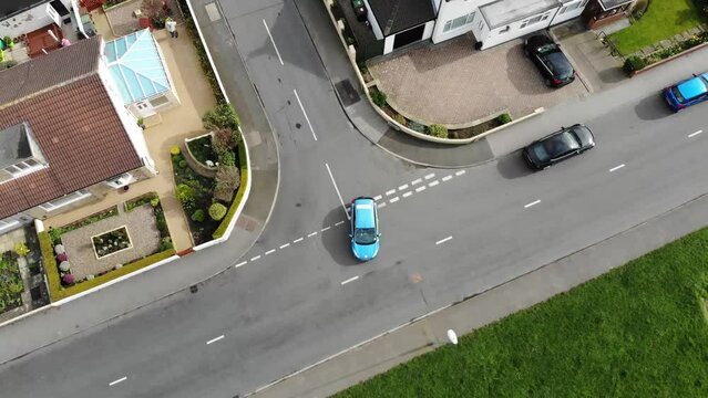 Aerial drone footage of a driving instructor teaching a student how to do a stop at a junction and turn right