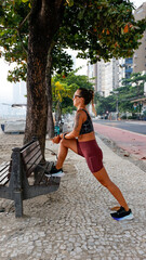 Mulher correndo na orla da praia 