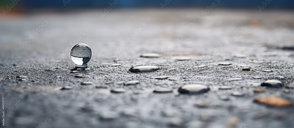 Poster close-up of a water droplet on a concrete surface with copy space image available.