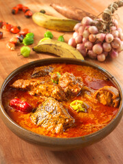 Sauce graine, Sauce graine in brauner rustikaler Schale mit Zutaten auf Holzfond, Ghana, westafrikanisches Essen, 