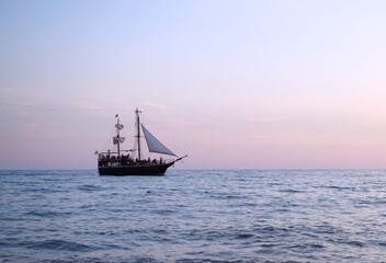 Fototapeta premium A ship with a sail is sailing on the sea.