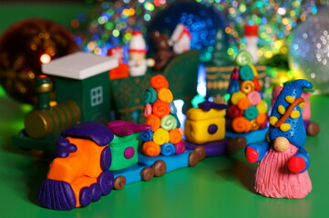 A toy train with plasticine gifts. Christmas background. New Year's holiday.
