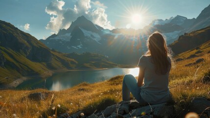 Naklejka premium A woman sitting on a rock looking at a lake