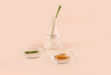 cosmetic ampoules, laboratory flasks and petri dishes on a beige background