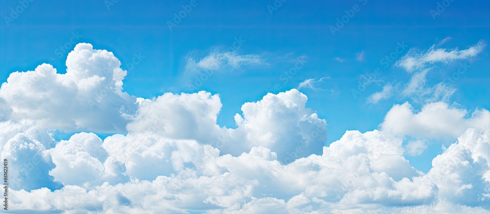Poster panoramic view of a blue sky with fluffy white clouds, perfect as a background for copy space image.