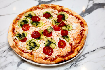 pizza with tomato and cheese on the table