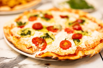 pizza with tomato and cheese on the table
