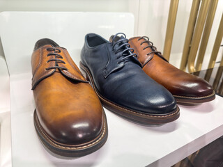 Stylish leather men's shoes on the shelf in the store in boutique