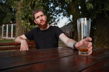 Man sitting with a glass of beer, drinking