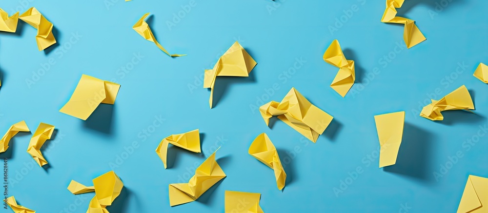 Poster fill half of the frame with a diagonal pattern of yellow paper origami question marks against a pale