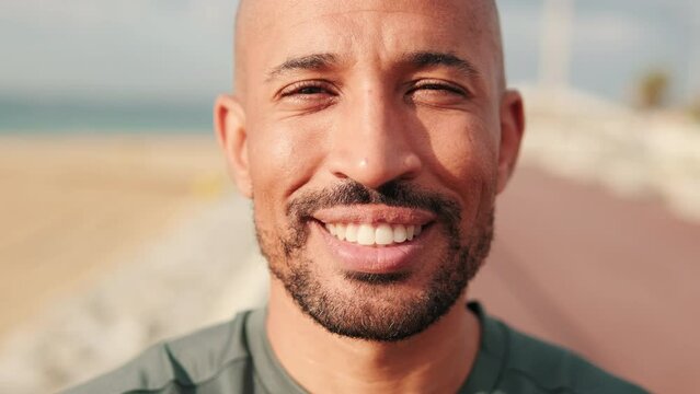 Close-up of hapy man smiling against blured background of the sea and sky 
