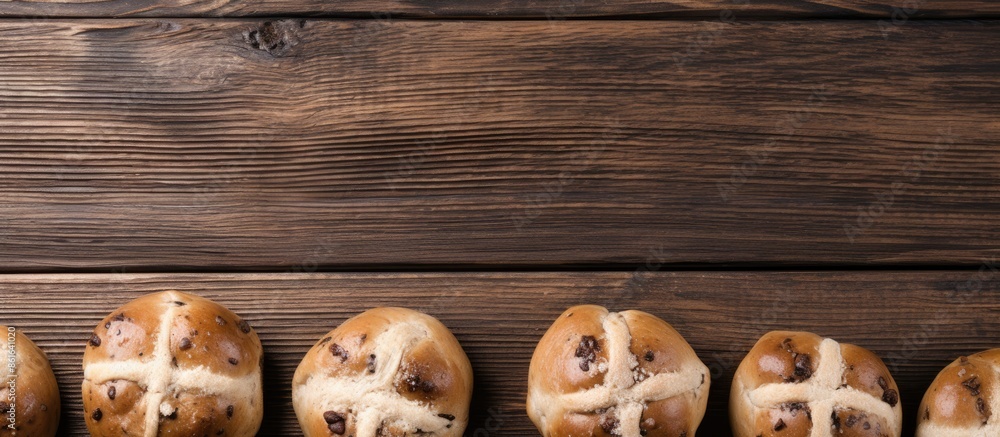 Poster Easter hot cross buns displayed from above on a wooden background with ample copy space for customization in the image.
