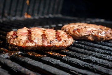 Homemade burger patty on a gas grill.  Ready to eat.