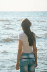 Young girl looking at the sea view and thinking at the overcast day