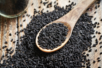 Black cumin or Nigella sativa seeds on a wooden spoon