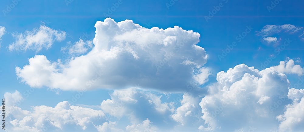 Poster panoramic view of a blue sky with fluffy white clouds, perfect as a background for copy space image.