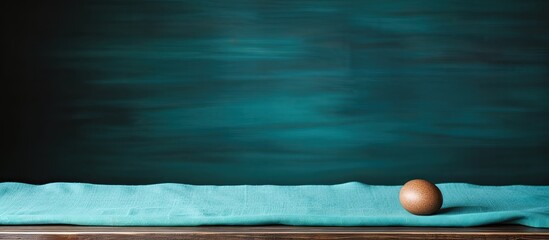 Walnut wood table background with teal linen cloth providing copy space image and a shallow focus.