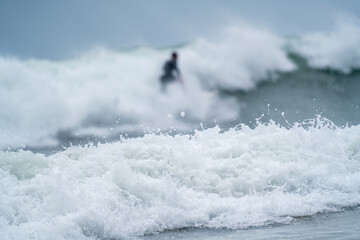 Naklejka premium Surfer in the Mist of Ocean Waves