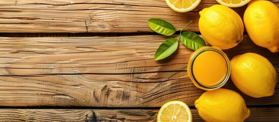 Top view of fresh lemons and lemon juice on a wooden background, with copy space image available for text.