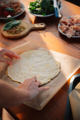 Making pizza dough. Female chef. Outdoor Dining table of Homemade Pizza, Fresh Ingredients and wine. Italian dream countryside romantic dinner 