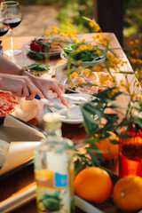 Prepping elegant female hands an outdoor Dining table of Homemade Pizza and Fresh Ingredients. Italian dream olive garden countryside romantic dinner 