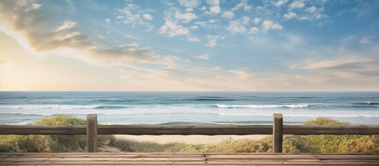 Fototapeta premium A wooden fence on a pier overlooking the sea offers a tranquil setting with a beautiful copy space image.
