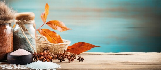 Autumn spa still life setting with plant, bath salt on wood backdrop. Features assorted essential oil and sea salt with copy space image, promoting fall wellness and aromatherapy theme.