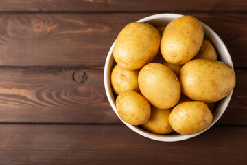 Young potatoes. Fresh potatoes  on a wooden background.Harvesting collection. organic, freshly dug potatoes. Agricultural background. Vegan. Vegetables.Place for text.Copy space