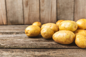 Young potatoes. Fresh potatoes  on a wooden background.Harvesting collection. organic, freshly dug potatoes. Agricultural background. Vegan. Vegetables.Place for text.Copy space