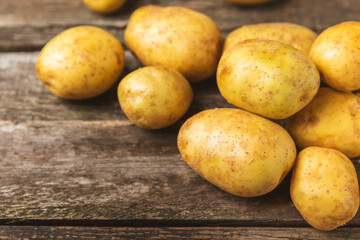 Young potatoes. Fresh potatoes  on a wooden background.Harvesting collection. organic, freshly dug potatoes. Agricultural background. Vegan. Vegetables.Place for text.Copy space