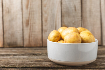 Young potatoes. Fresh potatoes  on a wooden background.Harvesting collection. organic, freshly dug potatoes. Agricultural background. Vegan. Vegetables.Place for text.Copy space