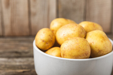 Young potatoes. Fresh potatoes  on a wooden background.Harvesting collection. organic, freshly dug potatoes. Agricultural background. Vegan. Vegetables.Place for text.Copy space
