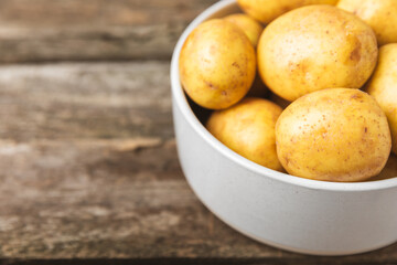 Young potatoes. Fresh potatoes  on a wooden background.Harvesting collection. organic, freshly dug potatoes. Agricultural background. Vegan. Vegetables.Place for text.Copy space