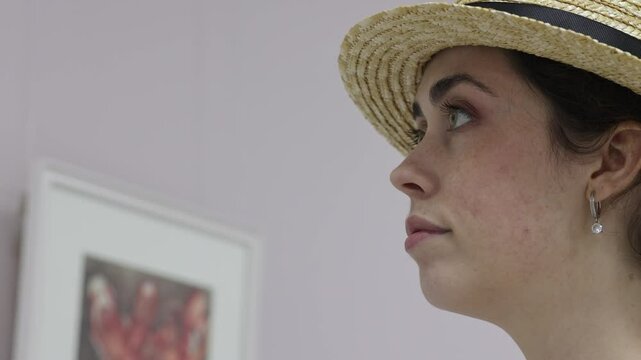 Close up view of pretty adult elegant Caucasian woman contemplating exposition with arts. Exhibition in gallery. Cultural education and Museum's Day