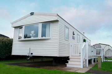 White Mobile Home With Deck and Steps in a Holiday Park