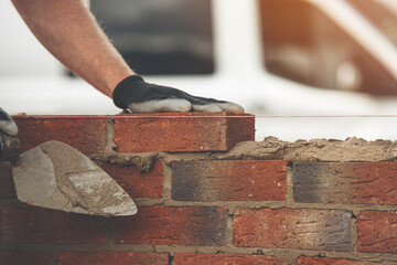 Construction Worker Laying Bricks With Mortar on Wall