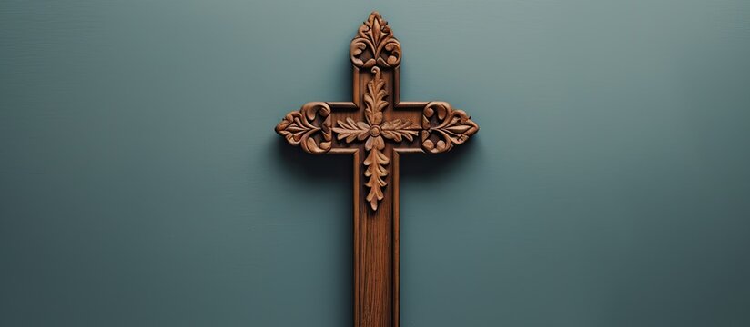 A top-down view of a wooden cross crucifix positioned with copy space. Depicts Catholicism and Christianity faith.