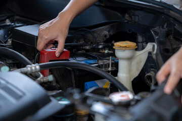 Fototapeta premium A young woman checking the engine of her car before setting off on a trip