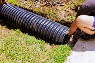 Installation of plastic black pipes for draining rainwater to central collector