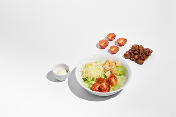 Deconstructed Caesar salad ingredients with neat geometry isolated on white background